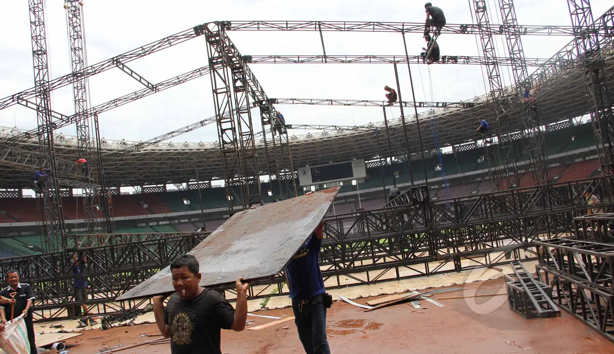 Pekerja membongkar penutup rumput (grass cover) usai konser One Direction di Stadion Utama Gelora Bung Karno (SUGBK), Jakarta, Kamis (26/3/2015). Lapangan SUGBK akan dipersiapkan untuk Pra-Piala Asia U-23. (Liputan6.com/Helmi Afandi)
