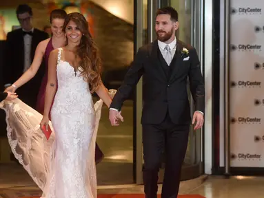 Bintang sepak bola, Lionel Messi berjalan di karpet merah bersama istrinya Antonella Roccuzzo di Rosario, provinsi Santa Fe, Argentina (30/6). Acara ini dihadiri banyak pesepakbola dan selebriti termasuk penyanyi pop Shakira. (AFP Photo/Eitan Abramovich)