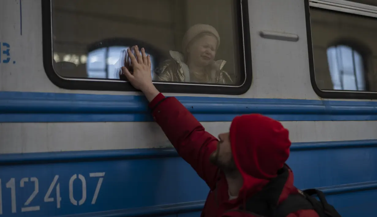 Pengungsi Ukraina di kereta api tujuan Polandia mengucapkan selamat tinggal di Lviv, 22 Maret 2022. Pada hari Selasa ketika perang Rusia yang tak henti-hentinya di Ukraina memaksa lebih banyak pengungsi untuk meninggalkan rumah mereka. (AP Photo/Bernat Armangue)