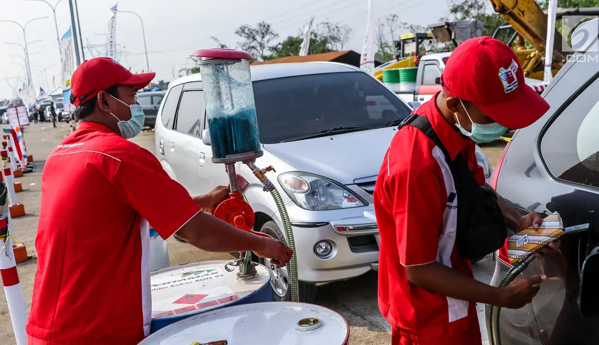 Petugas mengisi bahan bakar minyak (BBM) kendaraan di kios Pertamina tol fungsional (tol darurat) Brebes Timur-Gringsing, Tegal, Jawa Tengah, Jumat (30/6). PT Pertamina menjamin ketersedian BBM untuk arus balik aman. (Liputan6.com/Faizal Fanani)