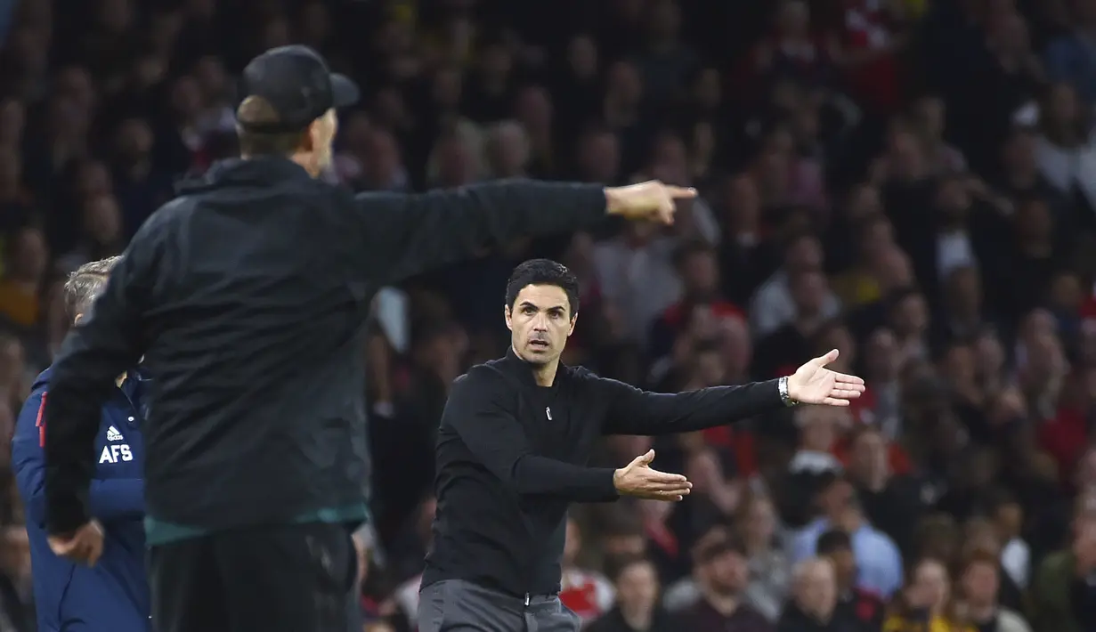 <p>Pelatih Arsenal, Mikel Arteta (kanan) dan pelatih Liverpool, Jurgen Klopp memberikan instruksi selama pertandingan lanjutan Liga Inggris antara Arsenal dan Liverpool di Stadion Emirates di London, Minggu (9/10/2022). Arsenal menang tipis atas Liverpool dengan skor 3-2. (AP Photo/Rui Vieira)</p>