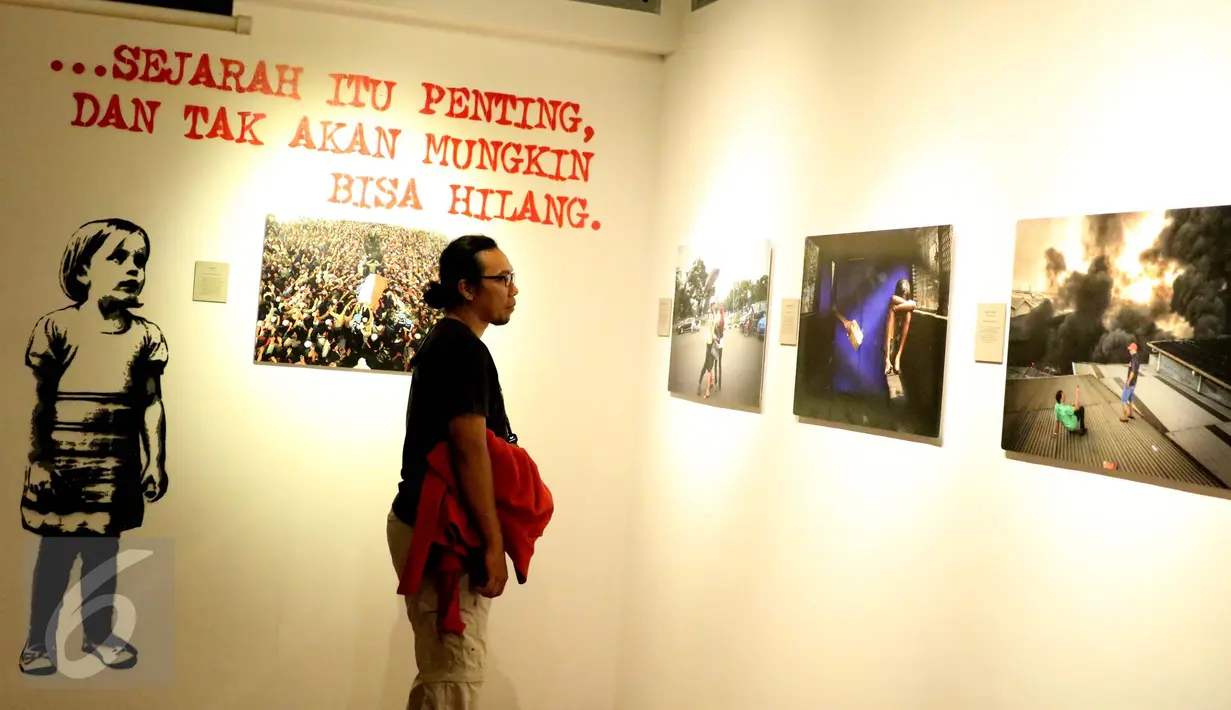 Pengunjung mengamati karya fotografi dalam Roadshow Pameran Fotografi Jurnalistik Anugerah Pewarta Foto Indonesia (APFI) 2016 di Galeri Foto Jurnalistik Antara, Jakarta, Minggu (9/10). (Liputan6.com/Gempur M. Surya)