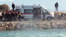 Petugas memasukkan korban tenggelam para imigran di distrik Altinoluk, Balikesir, Turki, (8/2). Diduga tenggelamnya perahu mereka karena sebuah kecelakaan. (STR / AFP)