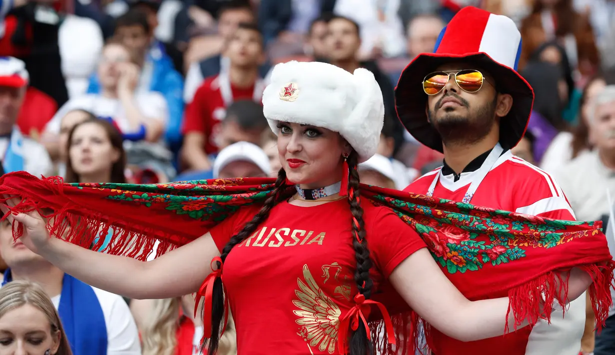 Suporter wanita tersenyum saat bersiap mendukung negaranya pada pertandingan grup A Piala Dunia 2018 antara Rusia dan Arab Saudi di stadion Luzhniki di Moskow, (14/6). Dalam pertandingan ini, Rusia menang 5-0 atas Arab Saudi. (AP Photo/Antonio Calanni)