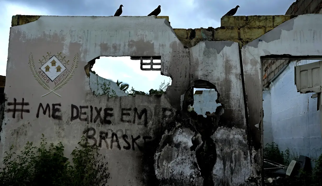 Grafiti tertulis di dinding rumah yang ditinggalkan di lingkungan Farol maceio, negara bagian Alagoas, Brasil, 6 Maret 2022. Farol adalah salah satu lingkungan yang telah ditinggalkan karena ancaman penurunan tanah yang disebabkan oleh tambang Braskem. (AP Photo/Eraldo Peres)