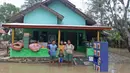 Keluarga Pak Unang berpose di depan kediamannya Desa Sumber Urip Pebayuran, Kabupaten Bekasi, Jawa Barat, Senin (22/2/2021). Banjir merenda keluarga tersebut merapikan barang-barang dan bersihkan rumah yang sudah surut. (Liputan6.com/Herman Zakharia)