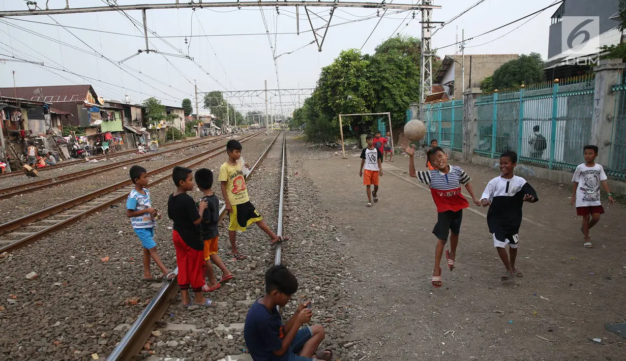 Suasana di pinggir rel kereta api di kawasan Kemayoran, Jakarta, Senin (24/7). Minimnya lahan bermain menyebabkan anak-anak terpaksa bermain di lokasi tersebut, meskipun berbahaya bagi keselamatan. (Liputan6.com/Immanuel Antonius)