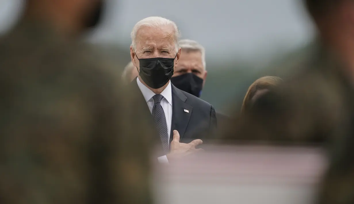 Presiden Joe Biden meletakkan tangan di atas jantungnya saat peti jenazah berisi Marine Corps Cpl. Daegan W. Page (23) tiba di Pangkalan Udara Dove Air, Delaware, Minggu (29/8/2021). 13 tentara AS yang tewas dalam serangan bom bunuh diri di dekat bandara Kabul tiba di tanah air. (AP/Carolyn Kaster)