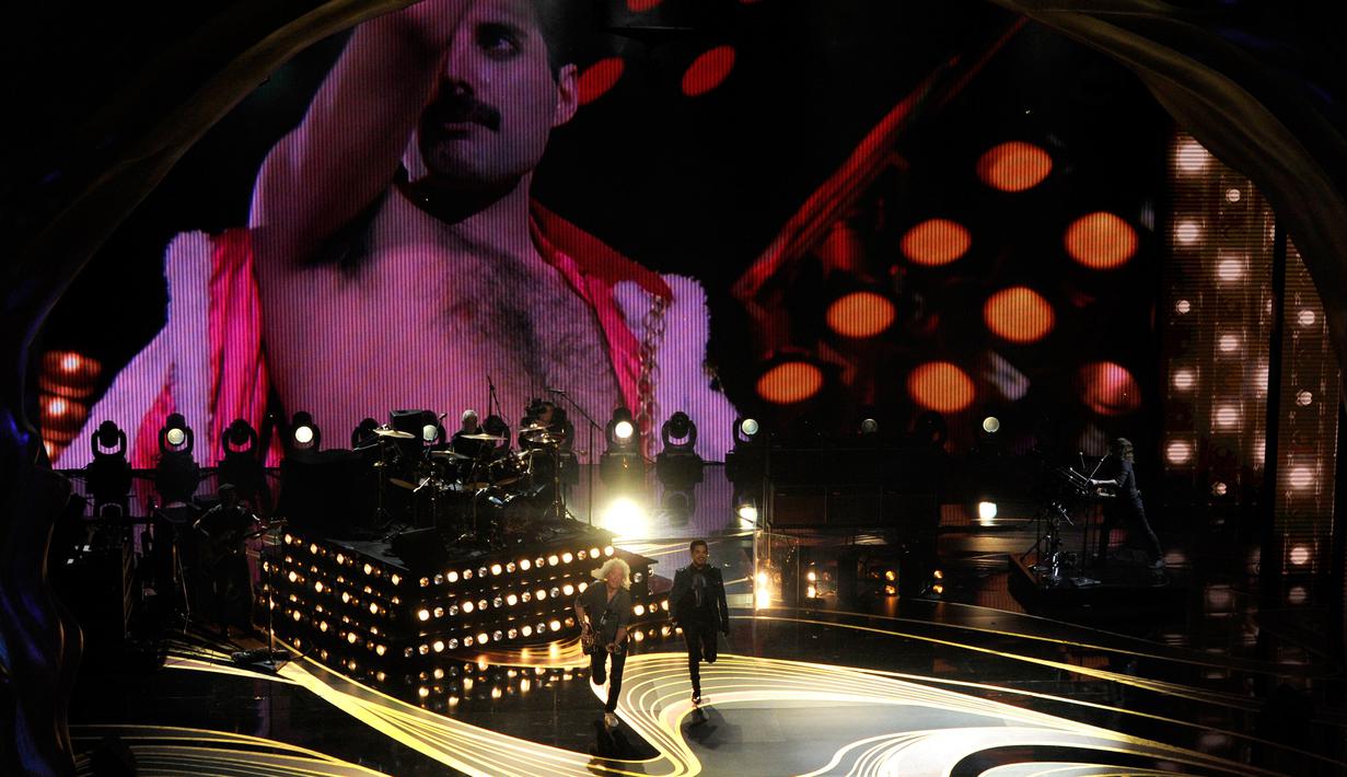 Penampilan band Queen dan Adam Lambert diiringin video Freddy Mercury saat membuka Oscar 2019 di Dolby Theatre, Los Angeles, Minggu (24/2). Lambert bergabung dengan tur Queen sejak 2011 menggantikan posisi Freddie Mercury. (Chris Pizzello/Invision/AP)