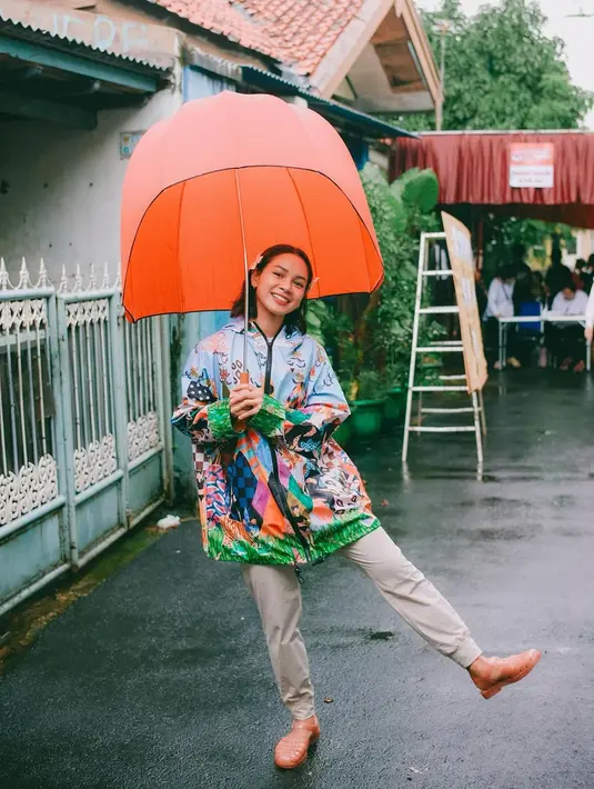 Hujan tak menghalangi Andien Aisyah untuk menggunakan hak suaranya. Ia datang ke TPS mengenakan jaket bermotif multi warna, long pants beige, sandal jelly dan oranye serba oranye-nya. [@andienaisyah]