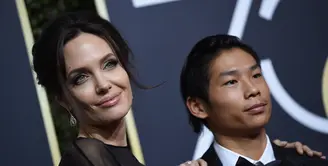 Angelina Jolie mengajak sang anak, Pax untuk menjadi temannya saat hadir di Golden Globe 2018. (VALERIE MACON / AFP)