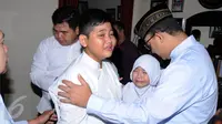 Mendikbud, Anies Baswedan (kanan) menenangkan anak Ketua KPU, Husni Kamil Manik di kompleks KPU, Jakarta, Jumat (8/7). Husni Kamil Manik wafat pada Kamis (7/7) di usia 40 tahun. (Liputan6.com/Helmi Fithriansyah)