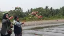 Keluarga menaburkan bunga ke laut dalam prosesi untuk lima jurnalis dan tiga kru kapal Arupadhatu 1 di pantai dekat Dermaga Pegedongan, Banten, Jumat (18/9/2026). Dermaga tersebut menjadi titik awal keberangkatan delapan orang itu pada Senin (7/9/2026). (KLY/Budy Santoso)