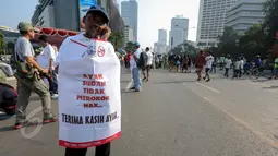 Aktivis mengenakan atribut bertuliskan "Ayah Sudah Tidak Merokok Nak" saat peringatan Hari Tanpa Tembakau di Bundaran HI, Jakarta, Minggu (31/5). Gerakan ini menyerukan para perokok agar tidak merokok selama 24 jam serentak. (Liputan6.com/Faizal Fanani)
