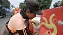 Pekerja dari PPSU Kelurahan Pegangsaan saat membuat lambang cabang olahraga di pembatas Jalan Penataran atau Simpang Tugu Proklamasi, Jakarta, Rabu (25/7). (Merdeka.com/Iqbal S. Nugroho)