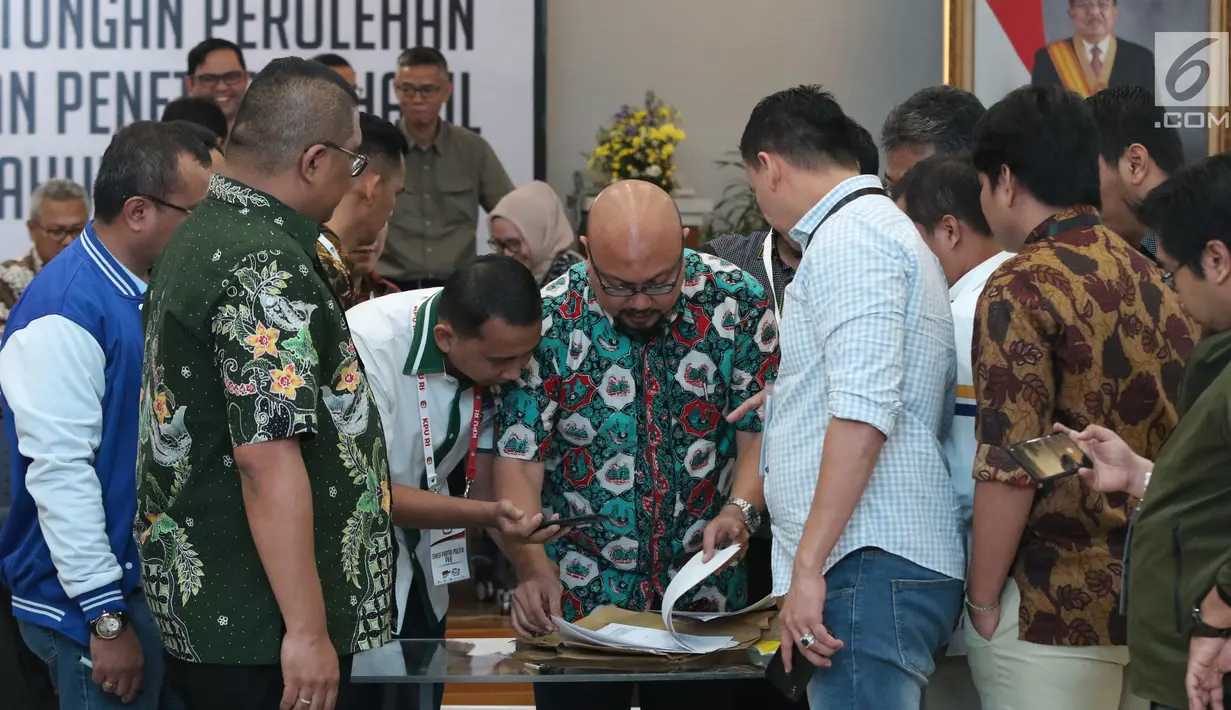 Komisioner KPU, Ilham Saputra (tengah) bersama perwakilan partai politik memeriksa dokumen hasil pemungutan suara di luar negeri saat rapat Rekapitulasi Hasil Penghitungan Perolehan Suara Tingkat Nasional dan Penetapan Hasil Pemilu 2019, Jakarta, Minggu (5/5/2019).(Liputan6.com/Helmi Fithriansyah)