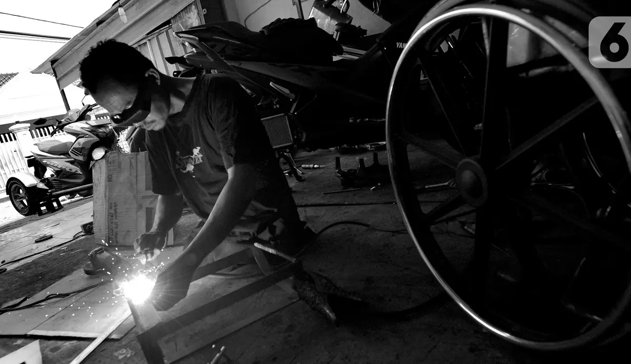 Penyandang disabilitas Catur Bambang (45) menyelesaikan pembuatan sepeda motor roda tiga di bengkelnya, Jalan Wijaya Kusuma, Ciputat Timur, Tangerang Selatan, Banten, Selasa (5/11/2019). Sepeda motor roda tiga diharapkan membantu penyandang disabilitas bermobilisasi. (merdeka.com/Arie Basuki)