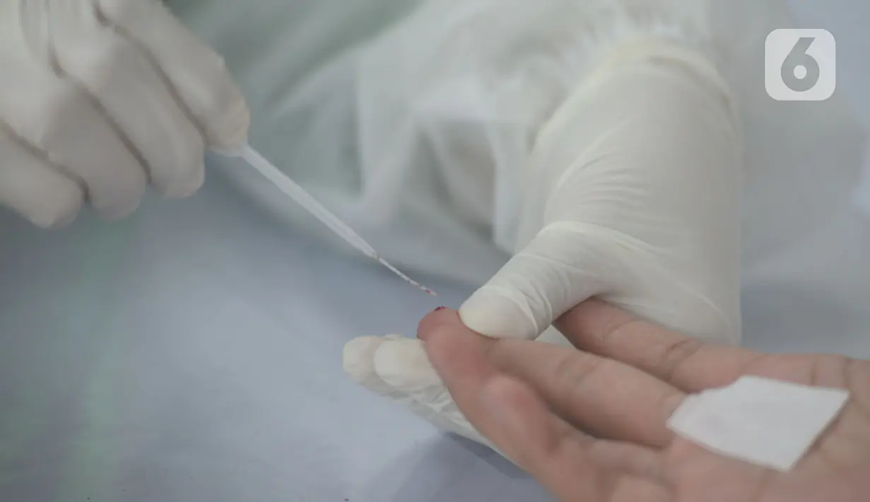 Petugas medis mengambil sampel darah warga saat mengikuti rapid tes Covid-19  di Bundaran HI, Jakarta, Selasa (26/5/2020). Rapid test massal tersebut diberikan secara gratis kepada 500 orang yang melintas atau beraktivitas di Bundaran HI guna mendeteksi COVID-19. (merdeka.com/Imam Buhori)