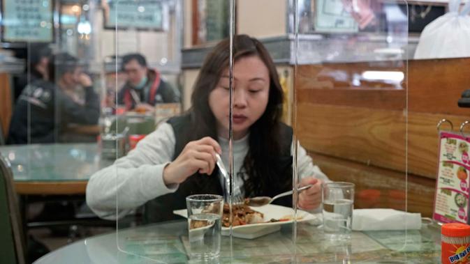 Pengunjung menikmati makan siang ditutupi panel plastik transparan untuk mengisolasi satu sama lain guna mencegah penyebaran virus corona di Hong Kong, 12 Februari 2020. WHO mengatakan wabah virus corona COVID-19 merupakan ancaman sangat besar bagi seluruh dunia. (AP/Kin Cheung)