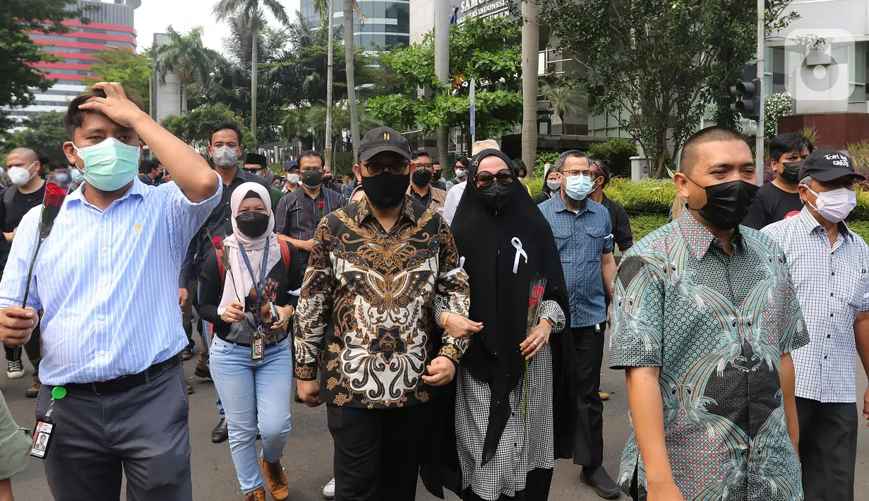 Pegawai KPK yang tidak lolos tes wawasan kebangsaan (TWK) Novel Baswedan (tengah) bersama sang istri Rina Emilda meninggalkan Gedung KPK di Jakarta, Kamis (30/9/2021). 57 + 1 pegawai KPK yang tak lolos TWK diberhentikan dengan hormat per 30 September 2021. (Liputan6.com/Herman Zakharia)