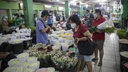 Warga memilih buket bunga di Pasar Bunga Rawa Belong, Jakarta, Senin (14/2/2022). Dari 50 paket menjadi 25 paket atau turun 50 persen per minggu dibandingkan sebelum Covid-19. (Liputan6.com/Faizal Fanani)