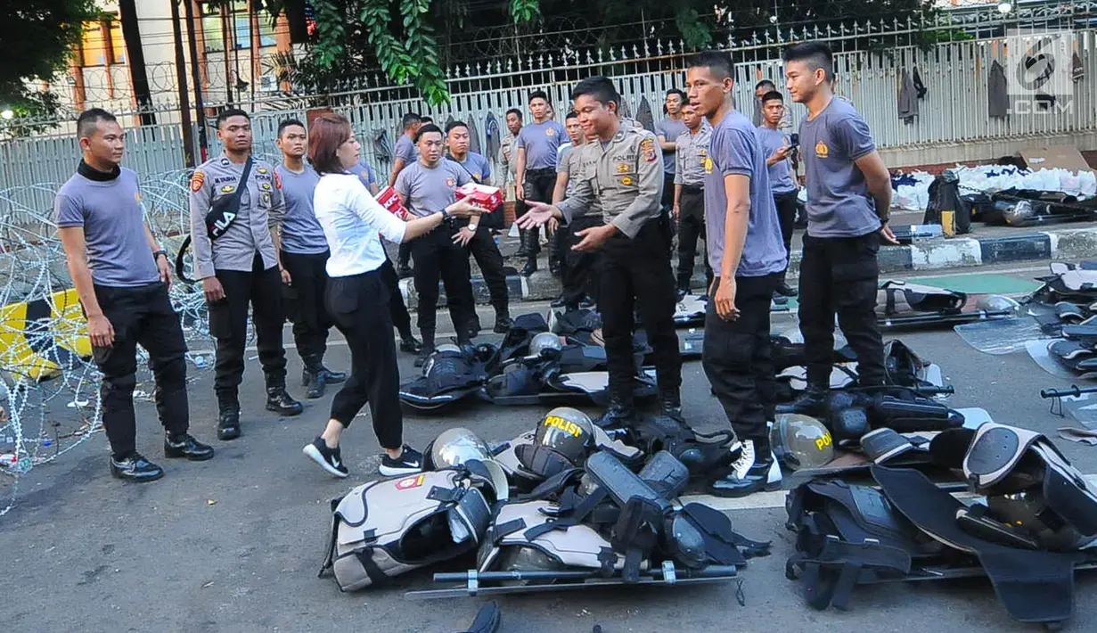 Relawan GOJO (Golkar Jokowi) memberikan makanan berbuka kepada para aparat yang melakukan penjagaan gedung KPU, Menteng, Jakarta Pusat, Kamis (23/5/). Makanan berbuka puasa ini diberikan sebagai bantuan kepada para aparat yang telah menjaga keamanan gedung KPU. (Liputan6.com/Angga Yuniar)
