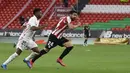 Penyerang Real Madrid, Rodrygo berebut bola dengan bek Athletic Bilbao, Mikel Balenziaga pada pekan ke-37 La Liga di San Mames, Minggu (15/5/2021). Real Madrid berhasil menang di laga sulit yang berlangsung di markas Bilbao dengan skor tipis 1-0. (AP Photo/Alvaro Barrientos)