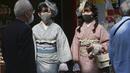 Pengunjung berpakaian kimono yang mengenakan masker untuk melindungi diri dari penyebaran virus corona berjalan-jalan di distrik perbelanjaan Asakusa di Tokyo, Jepang, Rabu (14/10/2020). Tokyo mengonfirmasi lebih dari 170 kasus virus corona baru pada hari Rabu. (AP Photo/Koji Sasahara)