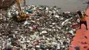 Pekerja kebersihan membersihkan sampah di Sungai Kanal Banjir Barat, Jakarta, Senin (14/11). Hujan yang terjadi di hulu Banjir Kanal Barat mengakibatkan meningkatnya debit air yang disertai sampah. (Liputan6.com/Johan Tallo)