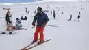 Seorang pemain ski menuruni lereng di resor ski Tochal di luar ibu kota Teheran, Iran (1/1/2022). Di tengah polusi udara dan kesengsaraan ekonomi, penduduk Teheran menemukan kenyamanan di resor ski di utara Teheran di pegunungan Alborz. (AP Photo/Vahid Salemi)