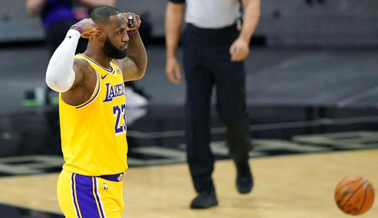 Pebasket Los Angeles Lakers, LeBron James, melakukan selebrasi saat melawan San Antonio Spurs pada laga NBA di AT&T Center, Kamis (31/12/2020). LA Lakers menang dengan skor 121-107. (AP/Eric Gay)