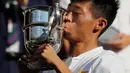 Petenis Taiwan Tseng Chun Hsin mencium trofi usai mengalahkan Jack Draper dari Inggris di final tunggal putra Kejuaraan Tenis Wimbledon Junior di London, (15/7). Petenis 16 tahun ini menang dengan skor 6-1, 6-7 (2/7), dan 6-4. (AP Photo/Ben Curtis)