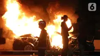 Sebuah mobil plat merah atau mobil dinas dibakar massa di kawasan Gondangdia, Jakarta, Kamis (8/10/2020). Unjuk rasa menentang disahkannya Omnibus Law UU Cipta Kerja berujung aksi anarkis merusak berbagai fasilitas umum. (Liputan6.com/Helmi Fithriansyah)