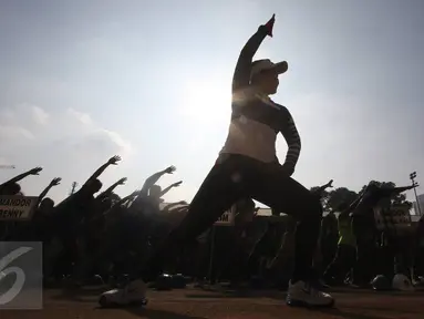 Pekerja renovasi Stadion Utama GBK mengikuti instruktur senam sebelum beraktivitas di kawasan Senayan, Jakarta, Jumat (17/3). Senam dilakukan untuk menjaga kebugaran pekerja yang rutin diadakan setiap Jumat pagi. (Liputan6.com/Immanuel Antonius)