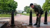 Seorang polisi taman AS memeriksa penghalang keamanan untuk kerusakan di taman Lafayette Square dekat Gedung Putih. [Alex Brandon/AP]