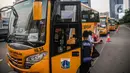 Petugas berjaga di depan bus sekolah yang terparkir di Kawasan Stasiun Sudirman, Jakarta, Jumat (19/6/2020). 50 armada bus sekolah ditempatkan di lima stasiun, yakni Tanah Abang, Manggarai, Juanda, Sudirman dan Tebet. (Liputan6.com/Faizal Fanani)