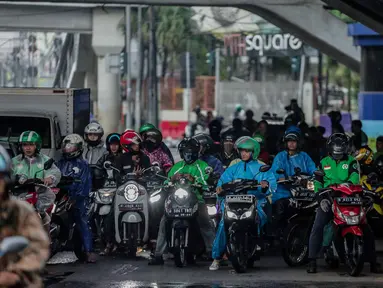 Pengendara sepeda motor memenuhi ruas jalan ketika berteduh di kolong Fly Over Cawang, Jakarta, Selasa (17/12/2019). Perilaku tersebut selain menimbulkan ketidaknyamanan pengguna jalan lainnya, juga memicu kemacetan. (Liputan6.com/Faizal Fanani)