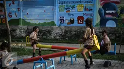Anak-anak bermain ayunan di RPTRA di Jalan Pluit Mas Utara, Kelurahan Pejagalan, Kecamatan Penjaringan, Jakarta (6/4). Salah satu fungsi RPTRA adalah agar masyarakat bisa saling mengenal dan menjadi tempat bermain anak. (Liputan6.com/Faizal Fanani)