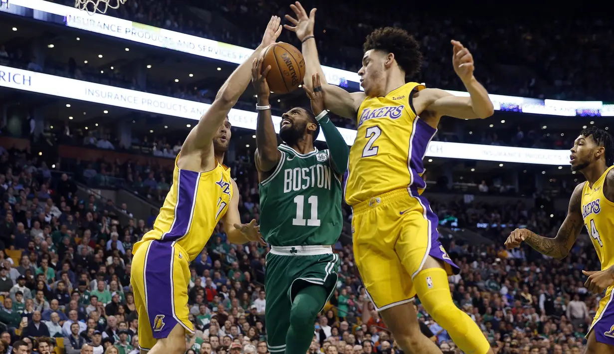 Pemain Boston Celtics, Kyrie Irving (11) berusaha melewati kawalan dua pemain Los Angeles Lakers pada laga NBA basketball game di TD Garden, Boston, (8/11/2017). Celtics menang 107-96. (AP/Winslow Townson)