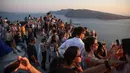 Wisatawan menunggu matahari terbenam di desa Oia di pulau Santorini, Yunani pada 20 Juli 2024. (Aris Oikonomou / AFP)