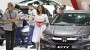 Model berpose di samping mobil yang dipamerkan pada Gaikindo Indonesia International Auto Show (GIIAS) 2019 di ICE BSD, Tangerang, Sabtu (20/7/2019). Kehadiran SPG atau model itu untuk menarik pengunjung serta memberikan informasi terkait produk otomotif yang ditawarkan. (Liputan6.com/Angga Yuniar)