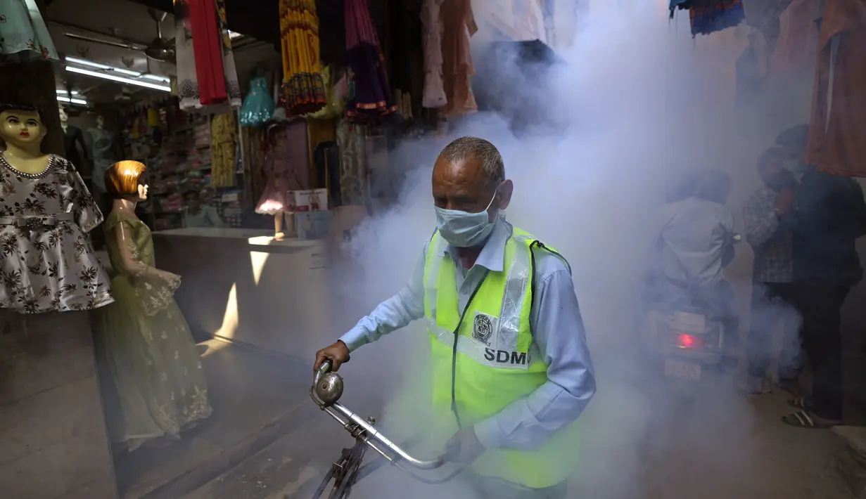 Pekerja kota melakukan fogging atau pengasapan daerah padat penduduk di New Delhi, India, Rabu (27/10/2021). New Delhi telah melaporkan ratusan kasus demam berdarah, dengan lebih dari 200 kasus baru dalam seminggu terakhir, menurut laporan yang dirilis pada hari Senin. (AP Photo/Manish Swarup)