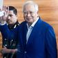 Mantan Perdana Menteri Najib Razak melambaikan tangan setibanya di kantor Komisi Anti-Korupsi Malaysia (MACC), Putrajaya, Selasa (22/5). Najib hari ini menjalani pemeriksaan terkait kasus korupsi 1Malaysia Development Berhad (1MDB). (AP/Sadiq Asyraf)