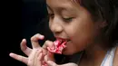 Seorang anak saat memakan permen yang berbentuk organ tubuh manusia di kota Meksiko, Jumat (30/10/2015). Permen dan beraneka jajanan berbentuk organ manusia ini dibuat untuk merayakan hari halloween. (REUTERS/Carlos Jasso) 