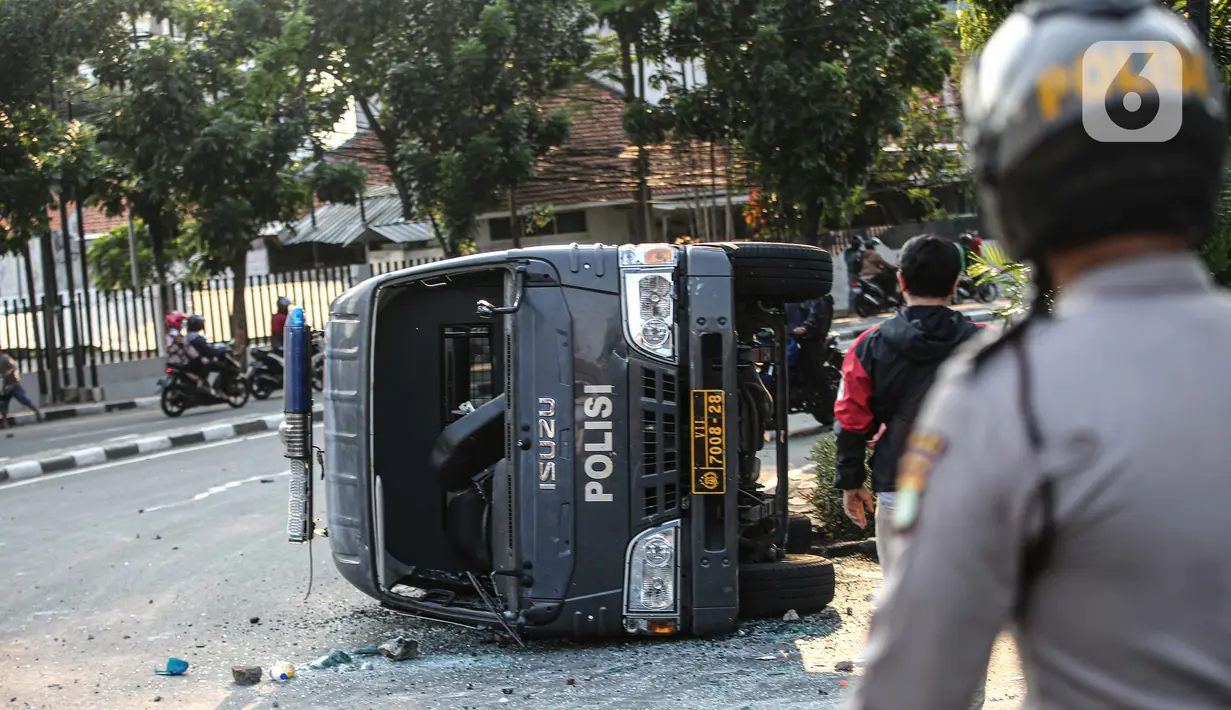 Sebuah mobil polisi dirusak massa saat bentrok di kawasan Pejompongan, Jakarta, Rabu (7/10/2020). (Liputan6.com/Faizal Fanani)