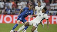 Gelandang Inggris Jude Bellingham berebut bola dengan pemain Serbia pada laga terakhir grup C Euro 2024 (AP)