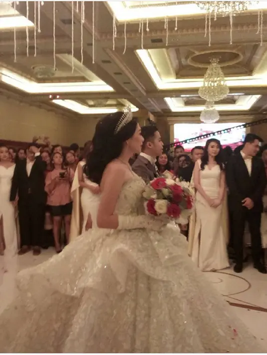 Dalam sebuah video yang dibagikan di Instagram, terlihat mantan personel Cherrybelle memakai gaun pengantin putih dan bermahkota saat menuju altar gereja. (dok. Instagram/axcelkeziawedding)
