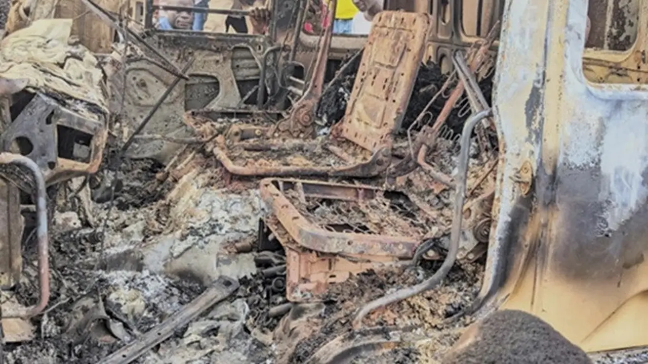 Orang-orang berkumpul di sekitar sisa-sisa hangus sebuah kendaraan yang terbakar setelah terjadi serangan mematikan di Komanda, Provinsi Ituri, Kongo, Minggu, (27/7/2025).