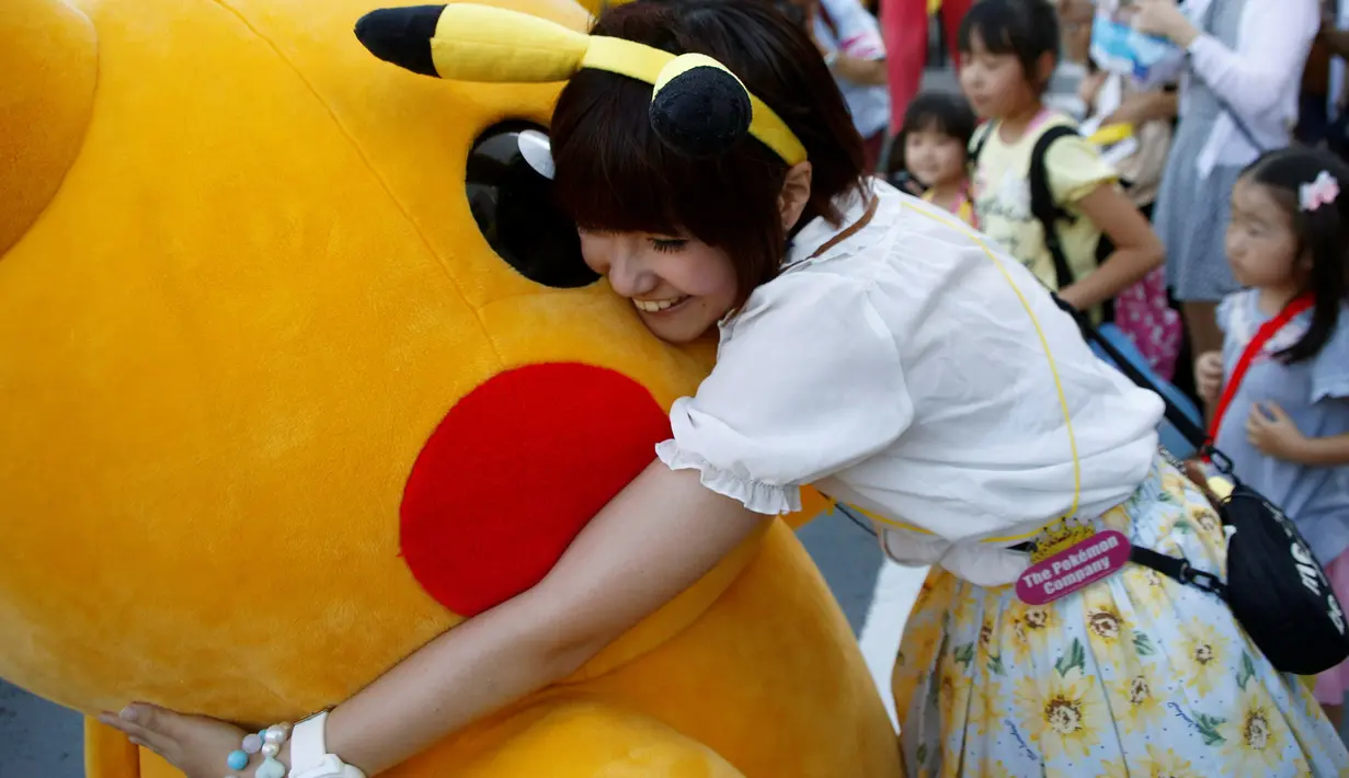 Seorang wanita memeluk Pikachu dalam serial animasi Pokemon melakukan parade di Yokohama , Jepang , 7 Agustus 2016. (REUTERS / Kim Kyung - Hoon)