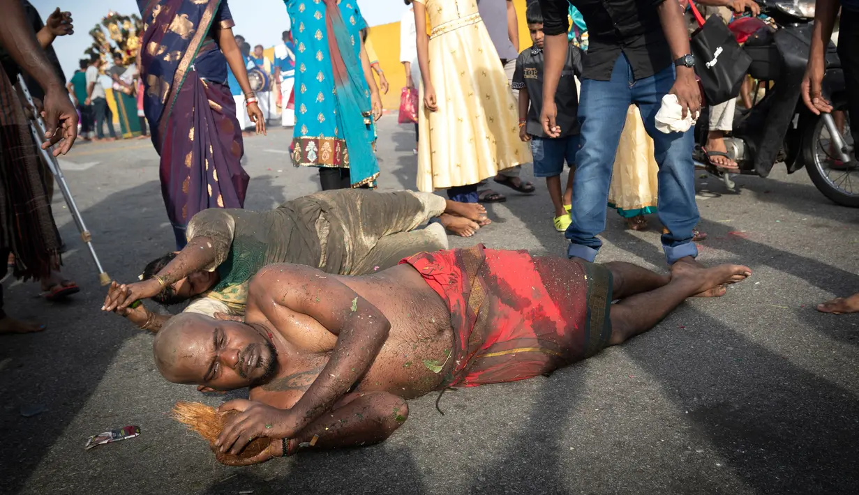 Umat Hindu berguling-guling di tanah selama Festival Thaipusam di Gua Batu, Kuala Lumpur, Malaysia, Senin (21/1).  Berbagai cara menyiksa diri dilakukan sebagai bentuk mereka memohon ampun. (AP Photo/ Vincent Thian)